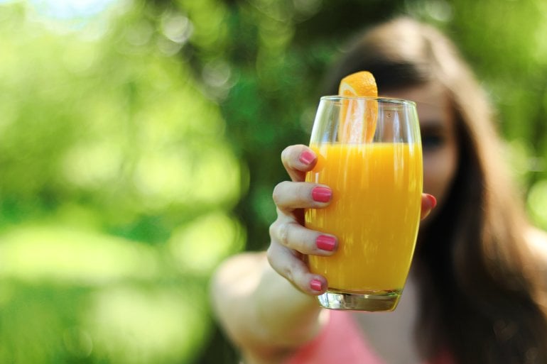 Frau fastet mit Orangensaft