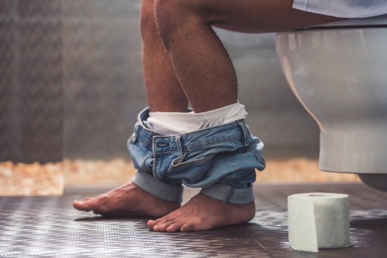 Mann mit Stuhlinkontinenz auf Toilette