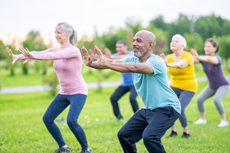 Menschen praktizieren Tai Chi im Park