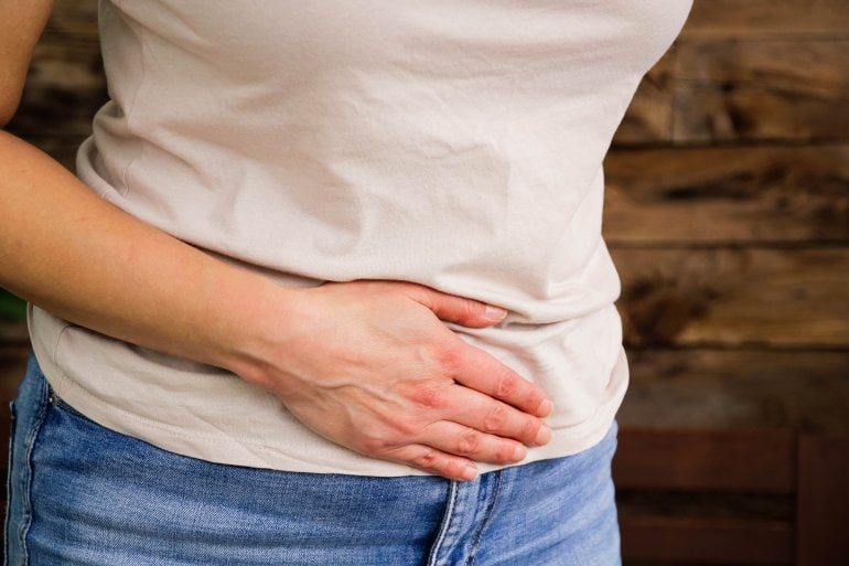 Frau mit Unterleibsschmerzen hält sich den Bauch