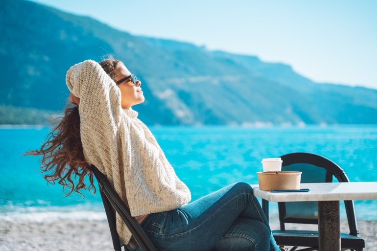 Frau sonnst sich am See, um Vitamin D zu produzieren